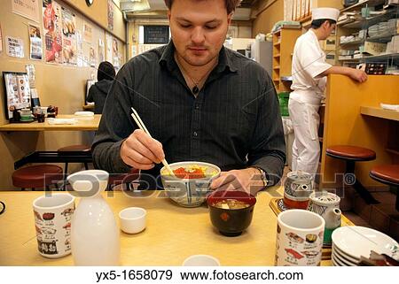 European tourist dining at a traditional Japanese restaurant in Tokyo View Large Photo Image Stock Photo - European tourist dining at a traditional Japanese restaurant in Tokyo. Fotosearch