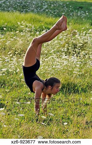 Stock Photo - European young doing gymnastics in a meadow in the Pyrenees. Fotosearch