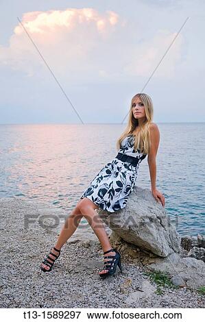 Evening posing on the rock young woman View Large Photo Image Stock Photo - Evening posing on the rock young woman. Fotosearch