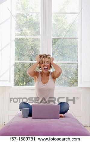 Stock Image - Exasperated young woman online. Fotosearch