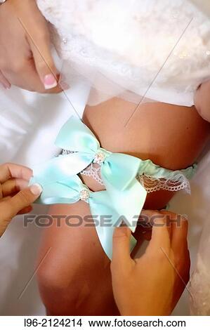excited bride slipping on her garter for the groom to remove later View Large Photo Image Picture - excited bride slipping on her garter for the groom to remove later. Fotosearch
