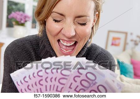 Stock Photograph - Excited woman holding 500 Euro notes. Fotosearch