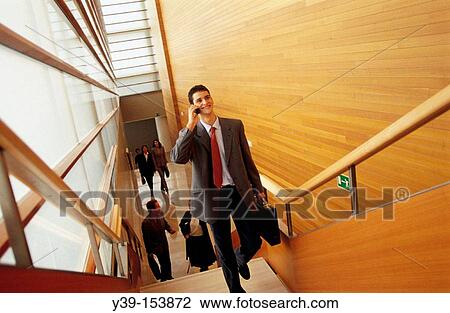 Stock Image - Executive climbing stairs. Fotosearch