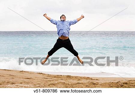 Executive jumping by the sea View Large Photo Image Stock Photograph - Executive jumping by the sea. Fotosearch