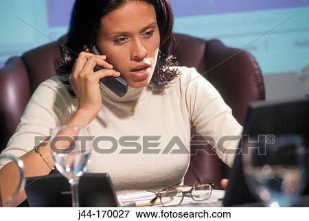 Executive latin woman talking on cellular phone in the office View Large Photo Image Stock Photo - Executive latin woman talking on cellular phone in the office. Fotosearch