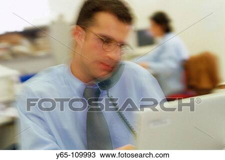 Executive on phone using laptop computer View Large Photo Image Stock Image - Executive on phone using laptop computer. Fotosearch