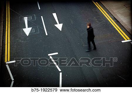 Executive talking on phone crossing the street View Large Photo Image Stock Photo - Executive talking on phone crossing the street. Fotosearch