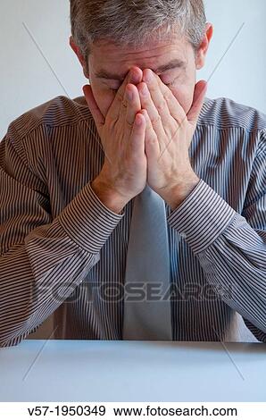 Stock Photo - Executive with face on hands. Close view.. Fotosearch