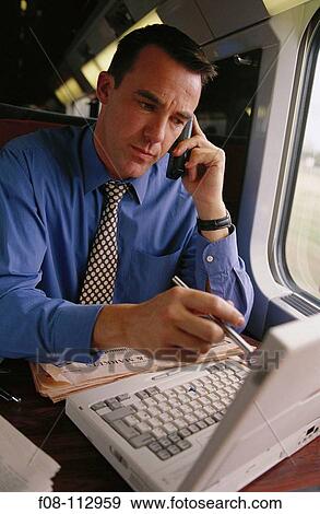 Executive with mobile phone and laptop computer View Large Photo Image Stock Photo - Executive with mobile phone and laptop computer. Fotosearch