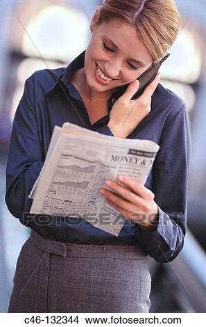 Executive woman with financial newspaper talking on cellular phone View Large Photo Image Picture - Executive woman with financial newspaper talking on cellular phone. Fotosearch