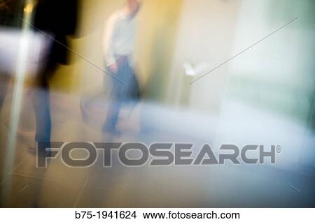 Picture - executives moving and blurred unrecognizable. Fotosearch