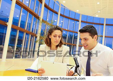 Stock Image - Executives with digital tablet, video conference. Fotosearch