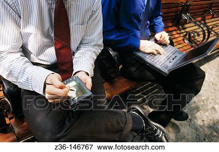 Stock Photo - Executives with laptop computer and palm pilot. Fotosearch