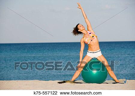 Stock Image - Exercise ball, beach, caucasian, hispanic, age 30 to 40.. Fotosearch