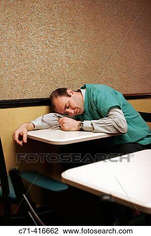 Stock Image - Exhausted sleeping surgeon. Fotosearch