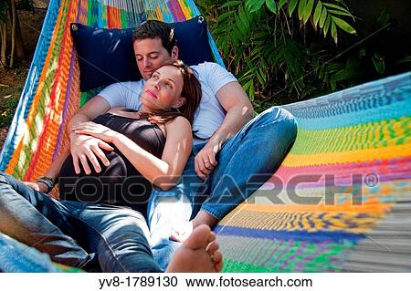 Exoecting couple relaxing inside a hammock View Large Photo Image Stock Image - Exoecting couple relaxing inside a hammock. Fotosearch