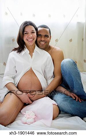 Expecting couple embracing View Large Photo Image Stock Photograph - Expecting couple embracing. Fotosearch