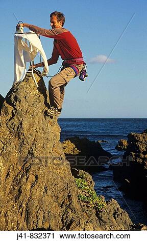Extreme ironing, ironing a shirt on top of a rock pinnacle Houghton Bay Wellington New Zealand View Large Photo Image Stock Image - Extreme ironing, ironing a shirt on top of a rock pinnacle Houghton Bay Wellington New Zealand. Fotosearch