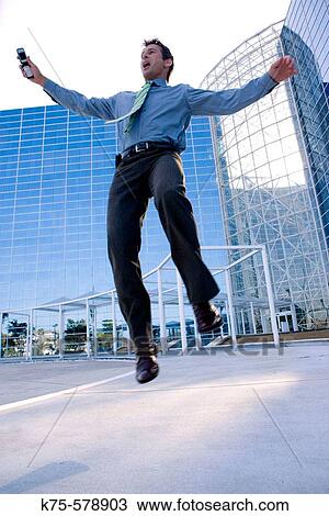 Exuberant man outside modern office building View Large Photo Image Stock Image - Exuberant man outside modern office building. Fotosearch