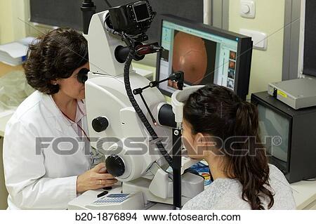 Eye examination Doctor using a retinal camera during an angiography examination of a patient's eye View Large Photo Image Picture - Eye examination Doctor using a retinal camera during an angiography examination of a patient's eye. Fotosearch