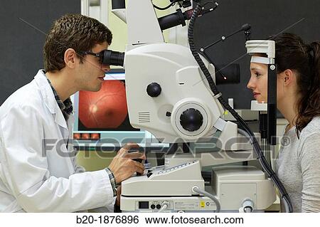 Eye examination Doctor using a retinal camera during an angiography examination of a patient's eye View Large Photo Image Stock Photograph - Eye examination Doctor using a retinal camera during an angiography examination of a patient's eye. Fotosearch