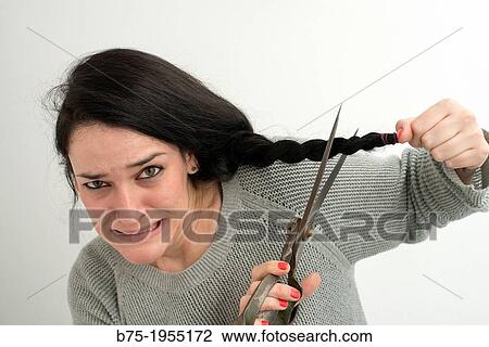 Stock Image - face young woman with panic making herself a haircut. Fotosearch