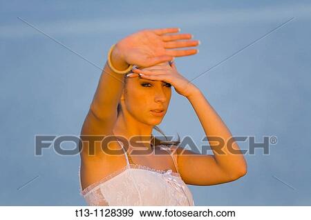 Facing the sun, young woman is lit by a warm sunset View Large Photo Image Stock Photo - Facing the sun, young woman is lit by a warm sunset. Fotosearch