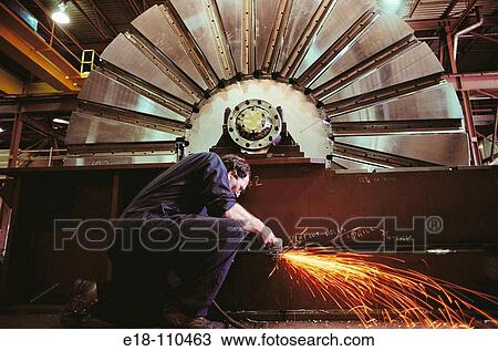 Factory worker grinding metal with huge saw blade in background, Vancouver. British Columbia, Canada View Large Photo Image Stock Image - Factory worker grinding metal with huge saw blade in background, Vancouver. British Columbia, Canada. Fotosearch
