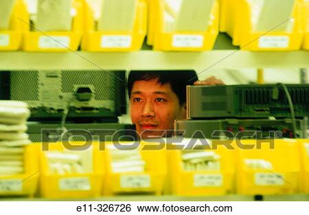 Factory worker with components for cellular industry View Large Photo Image Stock Photograph - Factory worker with components for cellular industry. Fotosearch