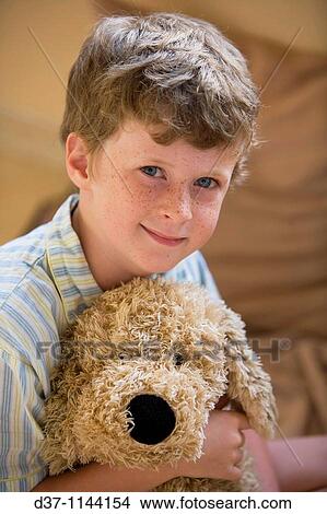 Fair-haired boy in bed hugging a cuddly toy View Large Photo Image Picture - Fair-haired boy in bed hugging a cuddly toy. Fotosearch