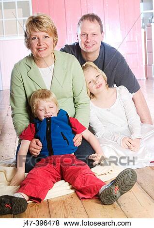 Familly of four, sitting smiling into camera View Large Photo Image Stock Photo - Familly of four, sitting smiling into camera. Fotosearch