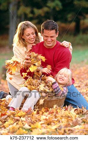 Stock Image - Family and a basket of leaves. Fotosearch