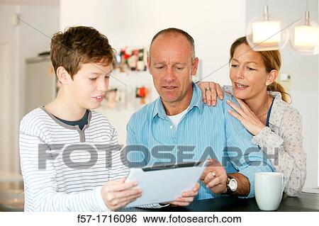 Family at home using tablet computer View Large Photo Image Stock Photograph - Family at home using tablet computer. Fotosearch