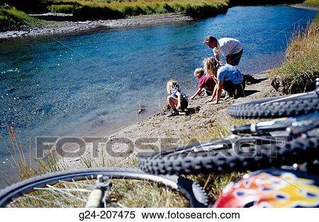 Stock Photography - Family exploring by river's edge. Banff. Alberta. Canada. Fotosearch