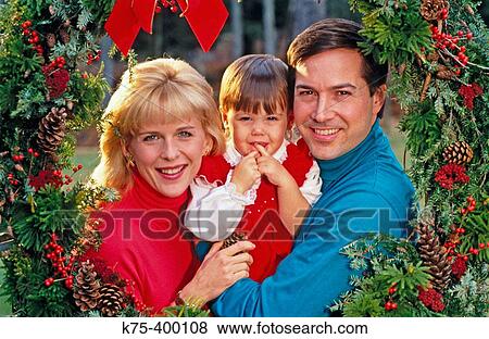 Stock Photo - Family framed by Christmas wreath. Fotosearch