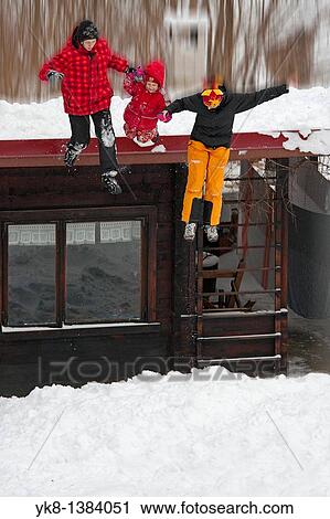 Stock Image - Family Hand in Hand Jumping Down From Roof into Snow. Fotosearch
