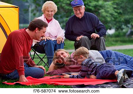 Family, including father and grandparents, camping, on lawn chairs, playing checkers. View Large Photo Image Picture - Family, including father and grandparents, camping, on lawn chairs, playing checkers.. Fotosearch