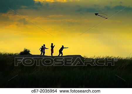 Picture - Family kite flying on Cley beach Norfolk.. Fotosearch
