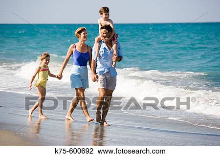 Family of 4 walking on beach View Large Photo Image Stock Image - Family of 4 walking on beach. Fotosearch