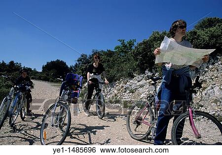 Family of cyclists stop to check their way on a map. View Large Photo Image Stock Photograph - Family of cyclists stop to check their way on a map.. Fotosearch