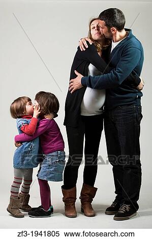 Family of four members in a photo studio kissing to each other. View Large Photo Image Stock Photography - Family of four members in a photo studio kissing to each other.. Fotosearch