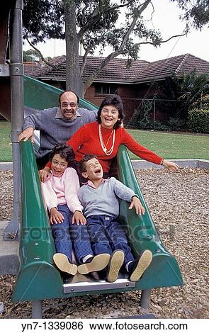 family of four posing on a slide in the local park View Large Photo Image Stock Photograph - family of four posing on a slide in the local park. Fotosearch
