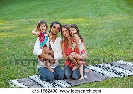 family of four sitting on blanket View Large Photo Image Stock Photo - family of four sitting on blanket. Fotosearch