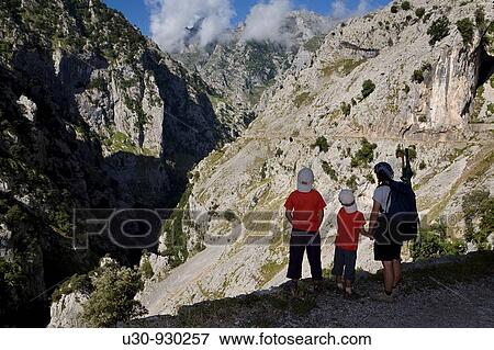 Stock Photo - Family of hikers walking along the route of the Cares Canyon, in the Picos de Europa National Park, between the Urrieles and? ndara massifs, Poncebos, Cantabria, Spain. Fotosearch