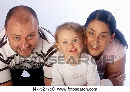 family of three, lying on tummies, smiling into camera View Large Photo Image Stock Image - family of three, lying on tummies, smiling into camera. Fotosearch
