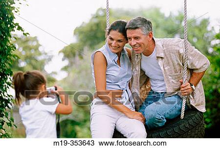 Stock Image - family on a tire swing. Fotosearch