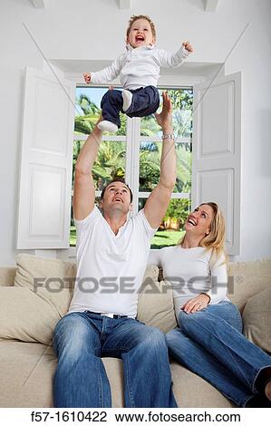 Family on their sofa throwing one year old baby in the air View Large Photo Image Stock Image - Family on their sofa throwing one year old baby in the air. Fotosearch