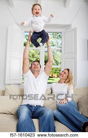 Family on their sofa throwing one year old baby in the air View Large Photo Image Stock Image - Family on their sofa throwing one year old baby in the air. Fotosearch
