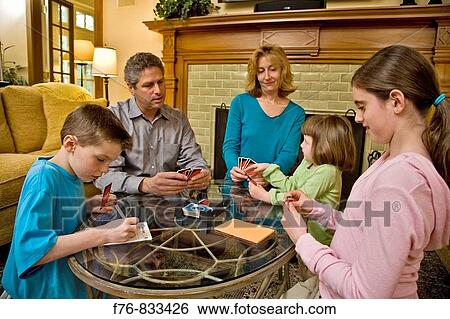 Family parents and three children playing card game in living room View Large Photo Image Stock Photograph - Family parents and three children playing card game in living room. Fotosearch