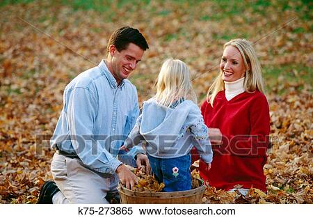 Stock Photography - Family playing in the leaves. Fotosearch